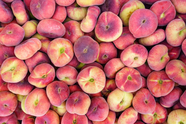 paraguayan sweet peaches stacked in a container box to the raw for sale, overhead photo. - nectarine peach red market imagens e fotografias de stock