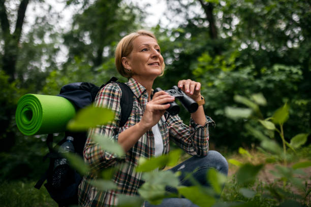 Female hiker watching birds through binoculars