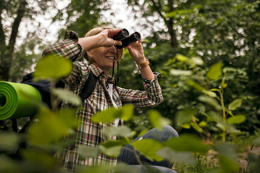 Hiker watching birds through binoculars