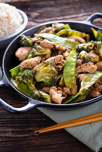 Healthy stir fried vegetables with chicken on pan close up