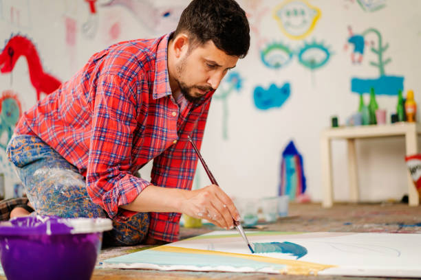 istock Skilled mid adult man painting canvas 1403680163