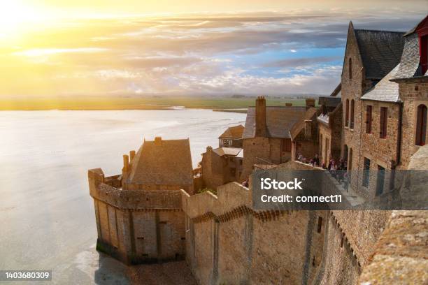 Ancient Fortress Walls Houses And Buildings Of The Ancient Cityfortress Of Mont Saintmichel In The Rays Of The Setting Sun Stock Photo - Download Image Now