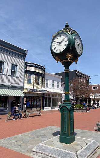 Stone Harbor, USA - April 17, 2022. Street view of downtown Stone Harbor with people walking on sidewalk or sitting on chairs, Stone Harbor, New Jersey, USA