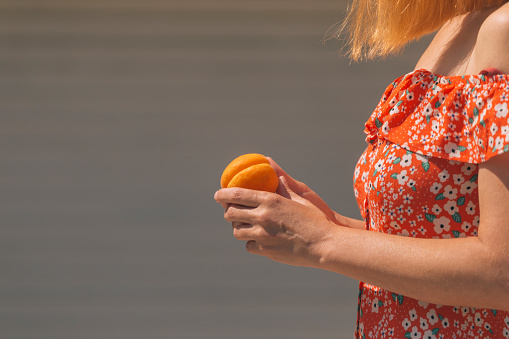 female holding ripe fresh apricot in her hands