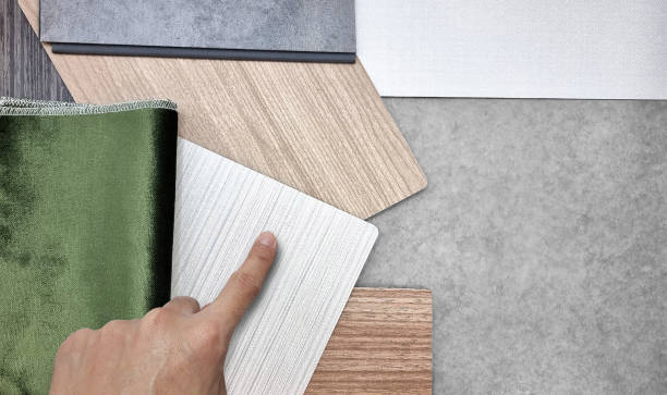 istock designer's hand selecting to interior material samples contains green velvet fabric, white fabric laminateds, oak wood veneers and concrete vinyl flooring. interior material board for presentation. 1403686529