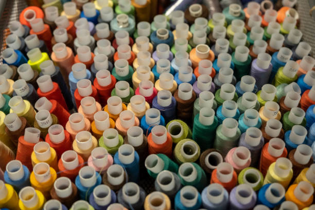 istock Colored thread for sewing. Threads in spools tape measure, needle bar, needle and scissors on a white background. 1403690015