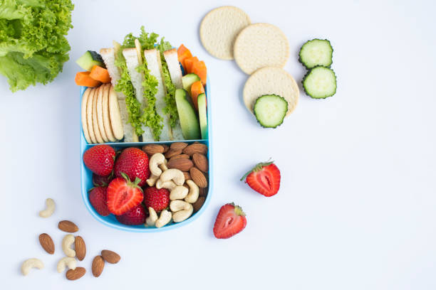 School lunch in the blue box on the white background. Top view. Copy space. School lunch in the blue box on the white background. Top view. Copy space. lunch box stock pictures, royalty-free photos & images