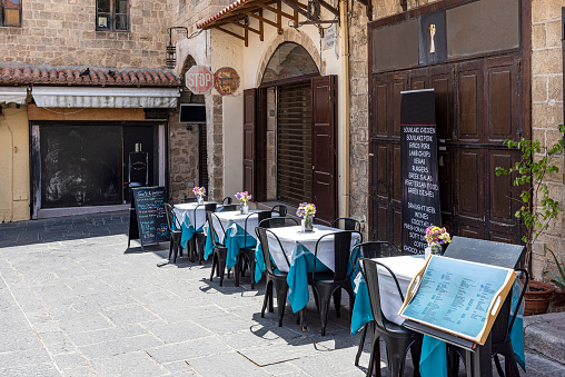 A view from the sidewalk cafe in the narrow streets of Rhodes old town in Greece.