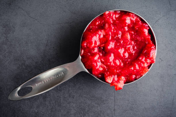 Measuring Cup Filled with Strawberry Puree Overhead view of a metal measuring cup filled with pureed strawberries strawberry crush stock pictures, royalty-free photos & images