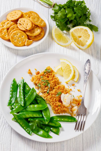 istock Baked Haddock with Crackers toppings and snow peas 1403698319