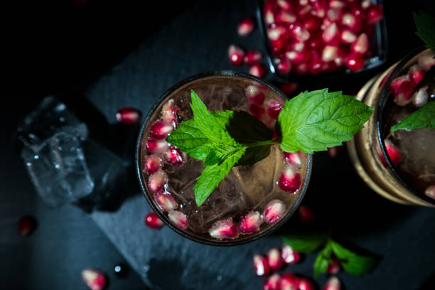 Two summer drinks with pomgranate, mint and some sugar. flat lay and black background stock photo