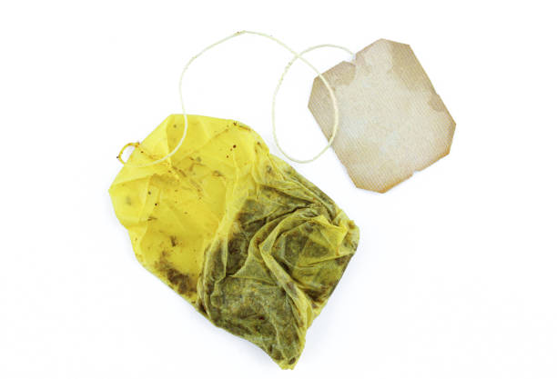 Used tea bag with blank label attached isolated on white background