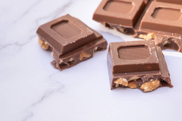 istock FOUR PIECES OF DARK CHOCOLATE ON A WHITE MARBLE TABLE. 1403705142
