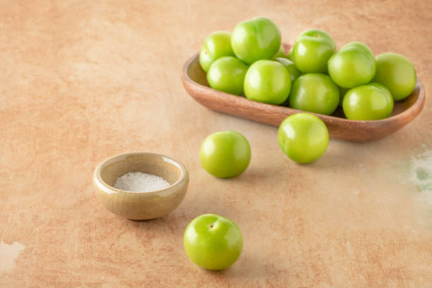 vista lateral frutas de ciruela verde madura servidas con sal en la mesa - plum yellow eating beauty and health fotografías e imágenes de stock