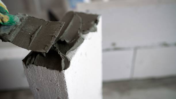 istock The process of building a house from a gas silicate block. The process of applying a solution-glue to aerated concrete block. 1403706520