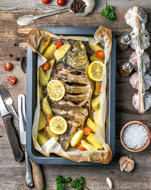 Appetizing baked fish with lemons, topview