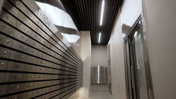 istock Modern, new hall in a multi-storey building. Corridor with postboxes on walls in new residential building. Modern entrance with mailboxes. 1403706717