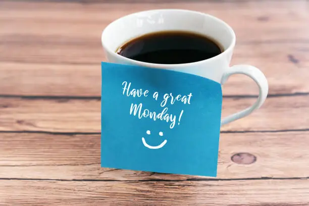 Inspirational quotes Happy Monday Greeting on adhesive note on a coffee cup