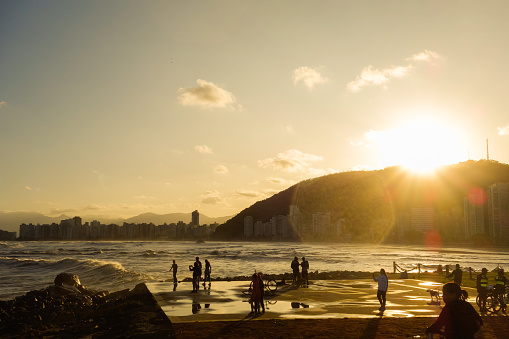 Santos, Brazil: people having fun at seacoast at sunset. Travel and summer concept