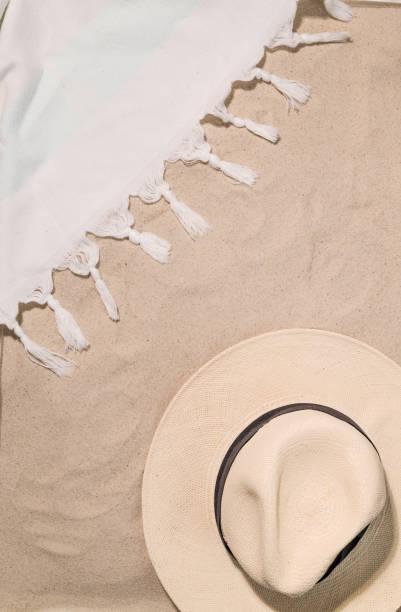Beach Towel on sand beach with sun hat for summer vacation
