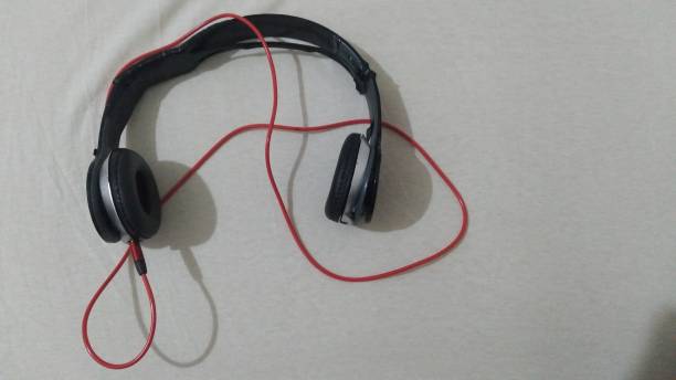 istock Broken earphones, red wired. cream color background 1403710057