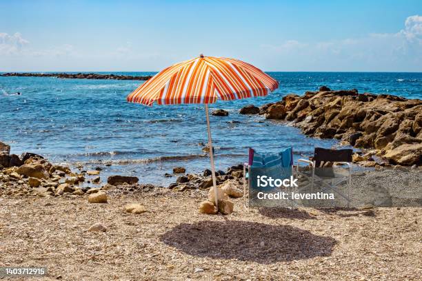 Sun Umbrella And Two Chairs On A Pebbly Beach In Monterosso Al Mare Stock Photo - Download Image Now