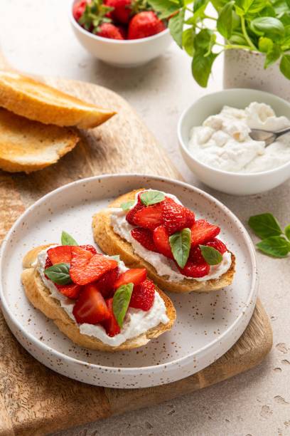 istock Bruschetta with goat cheese or ricotta witn strawberry and basil. Appetizer with berries. Summer healthy breakfast. Selective focus. 1403713049