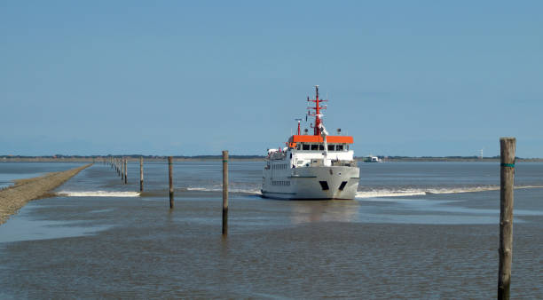 A passenger ferry from a Wadden Island approaches a harbor on the Wadden Sea
