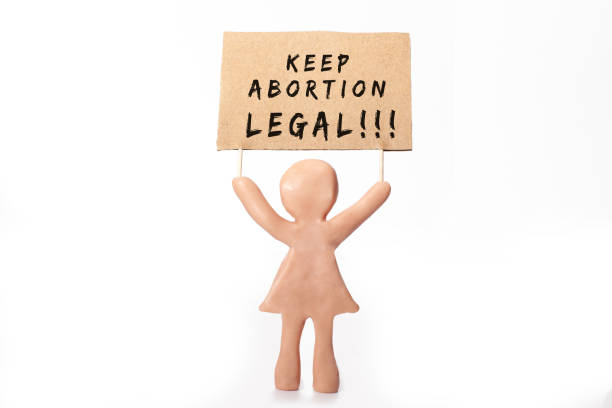 clay woman figurine with abortion protest banner clay woman figurine with abortion protest banner abortion photos stock pictures, royalty-free photos & images