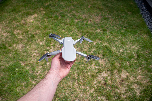 Calgary, Alberta, June 17, 2022: PMan holding a DJI Mini 2 drone in hand.