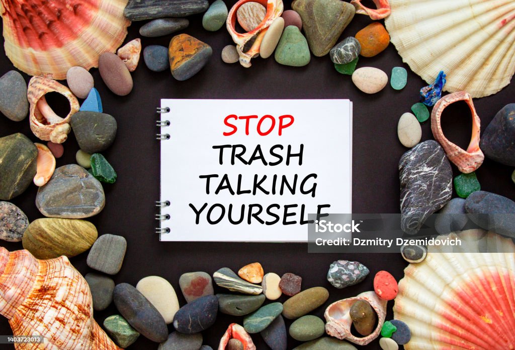 Stop trash talking yourself symbol. Concept words Stop trash talking yourself on a beautiful black background. Sea stones and seashells. Psychological and stop trash talking yourself concept. Copy space. Negative Emotion Stock Photo