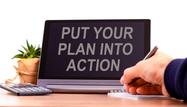 istock Put your plan into action symbol. Concept words Put your plan into action on the black tablet. Businessman hand with pen. Business planning put your plan into action concept. Copy space. 1403723022