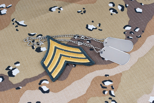 US ARMY Sergeant rank patch and dog tags on Desert Battle Dress Uniform