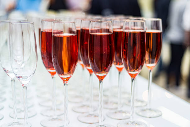 Champagne Rose glasses on the bar. Lots of glasses with drinks. Bright colored lights behind the glasses. Champagne Rose glasses on the bar. Lots of glasses with drinks. Bright colored lights behind the glasses. rose champagne stock pictures, royalty-free photos & images