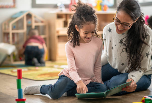 istock Teacher and student read a book together 1403734929