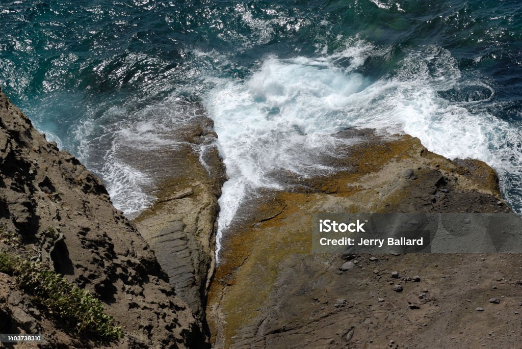 cliff view looking down at ocean rocky cliff with ocean at bottom, waves crashing on rocks, no people, sunny day, Antigua & Barbuda Stock Photo