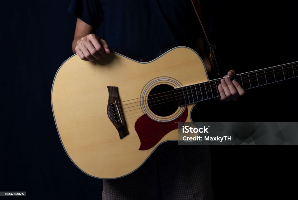 Musician at night, Player with an acoustic guitar in the dark, With side lighting. Adult Stock Photo