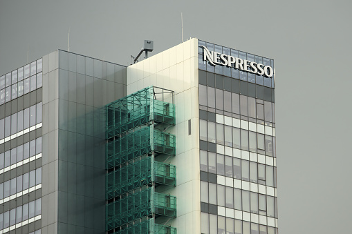 Bucharest, Romania - June 17, 2022: A logo of Nespresso, coffee capsules, coffee pods, coffee machines maker and operating unit of the Switzerland Nestle Group, is displayed on the top of a building.