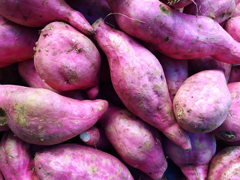 close up of a retail display of a pile of purple yams for sale by a street vendor in Chinatown, Manhattan, NYC