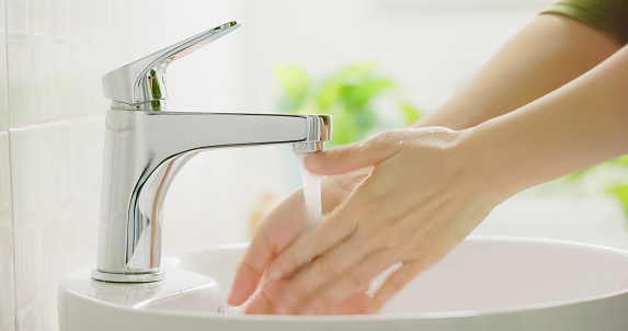 close up of asian woman washing her hands with water at tap to prevent infectious disease and covid-19