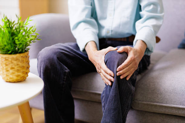 istock man holding knee with pain 1403751982