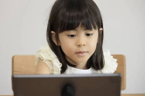 Japanese girl watching video on tablet PC (7 years old)