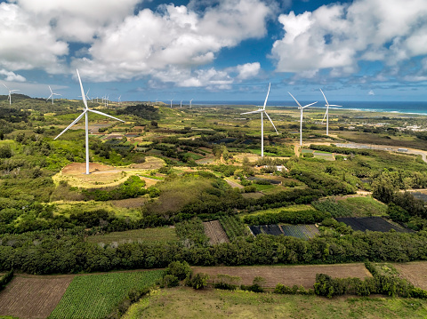 Wind power turbines on Kahuku Wind farm in Oahu, Hawaii. Blue sunny sky with white clouds