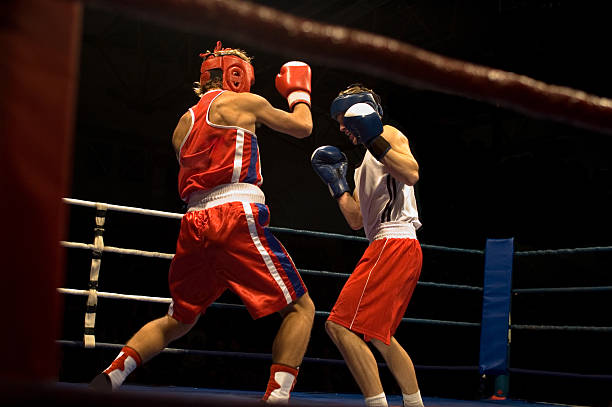 Agressive boxing fight Agressive boxing fight, two boxers fighting on the ring. boxing stock pictures, royalty-free photos & images