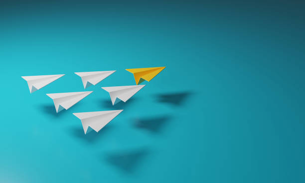 istock Yellow paper airplane leads a group of white planes. 1403762966