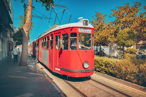 18 May 2022, Antalya, Turkiye: Red retro tram driving on the streets of Antalya. Travel transportation and attractions