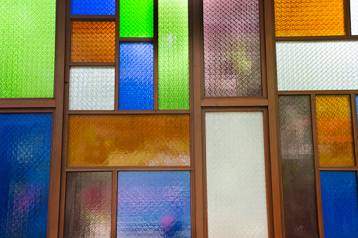 Interior design decorate wooden window and wood door with colorful stained glass background in architecture building at Wat Sangkhatan temple in Bang Phai of Nonthaburi, Thailand