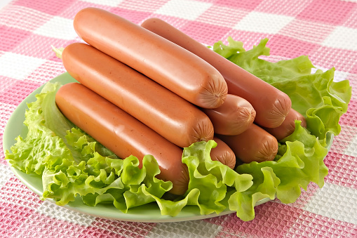 Appetizing pork sausages seasoned by green salad-product for preparation of hot dogs