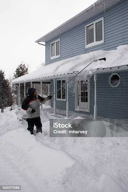 Photo libre de droit de Homme Shovelling La Neige Couvertes De Neige Du Toit banque d'images et plus d'images libres de droit de Hiver