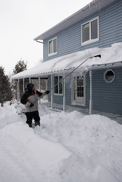 istock man shovelling snow from snow covered roof 140377088